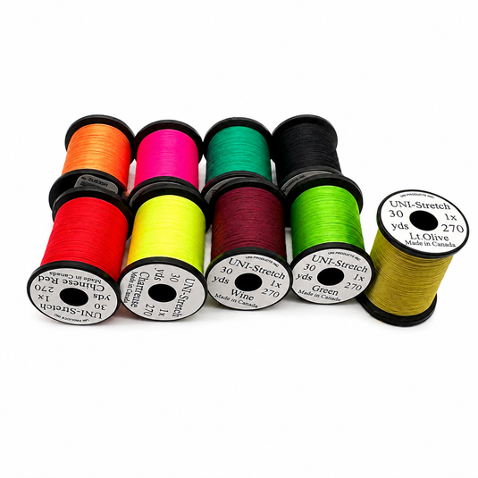 Assorted stretch thread spools in orange, magenta, green, black, and yellow-lime