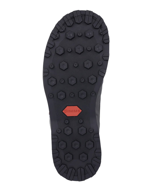 Rubber boot outsole with dark lug tread and red logo patch