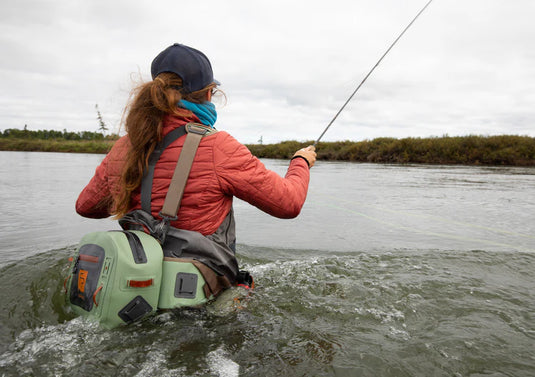 Green submersible lumbar pack worn on back with adjustable shoulder and waist straps.