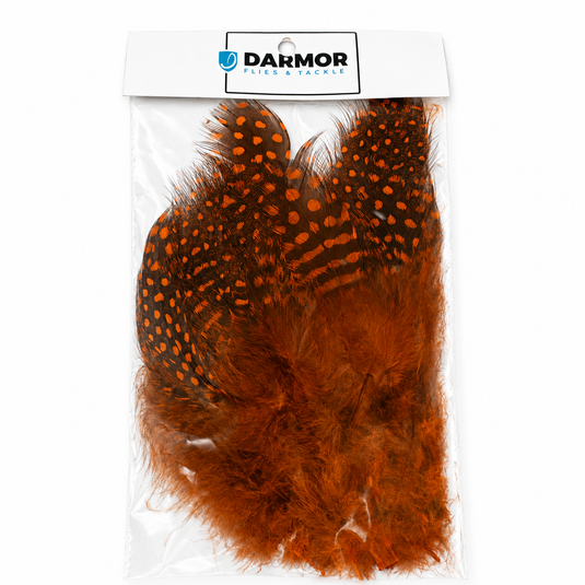 Guinea fowl feathers in orange with black speckles, sealed in a bag.