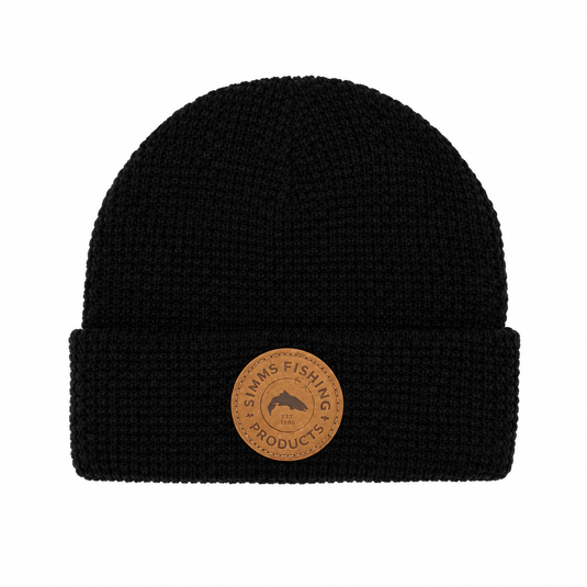 Black waffle-knit beanie with fold cuff and round Simms Fishing Products leather patch
