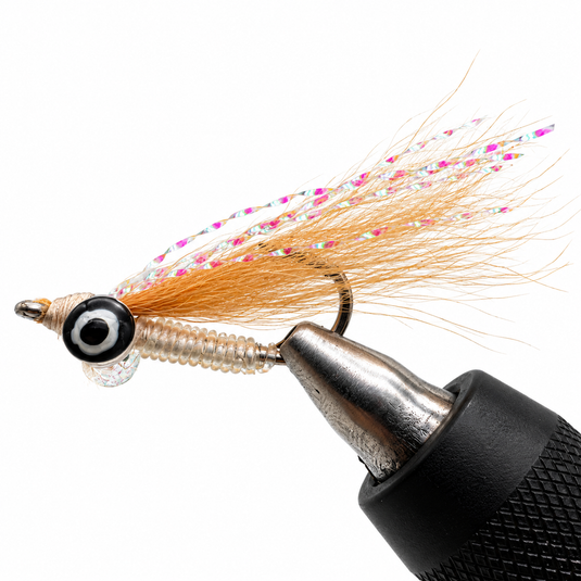 Fishing lure with metallic silver body, orange tinsel tail, and feathered wings