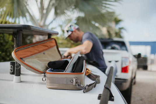 Rod and reel case open on car, gray interior with straps and compartments