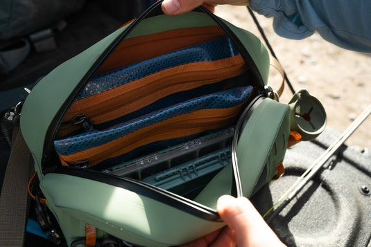 Open lumbar pack showing blue and orange storage dividers and mesh compartments