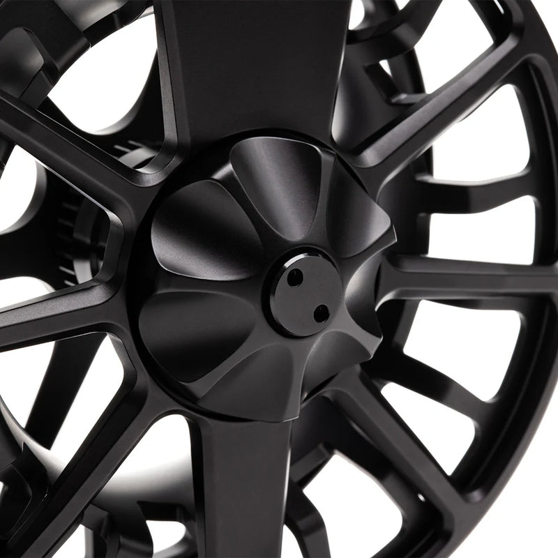 Load image into Gallery viewer, Close-up of black fly fishing reel spool with central screw and spokes
