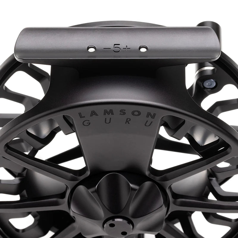 Load image into Gallery viewer, Black fly fishing reel top view with 'LAMSON GURU' on frame
