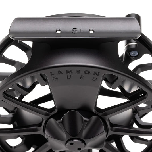 Black fly fishing reel top view with 'LAMSON GURU' on frame