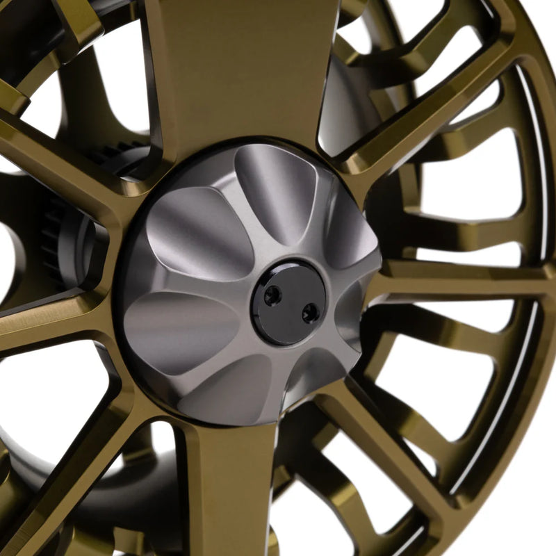 Load image into Gallery viewer, Close-up of olive gold fly fishing reel with silver center cap and spokes
