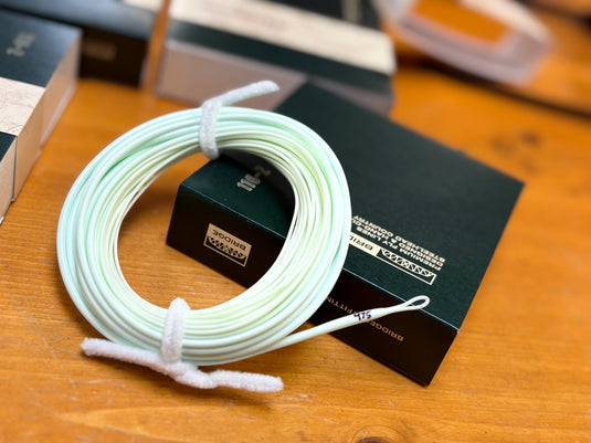 Coiled spey fly line with looped end on table, Bridge box behind