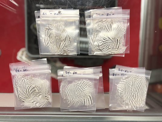 Bagged silver pheasant feather designs in clear plastic pouches