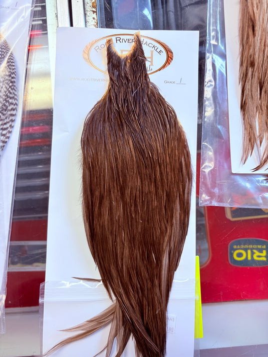 Dark brown hackle feather bundle with long tapered body and trailing wisps