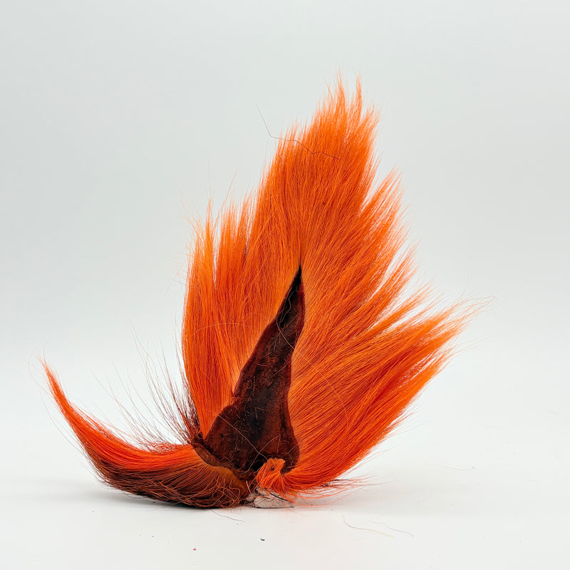 Load image into Gallery viewer, Orange bucktail-style fly tail with dark mottled base
