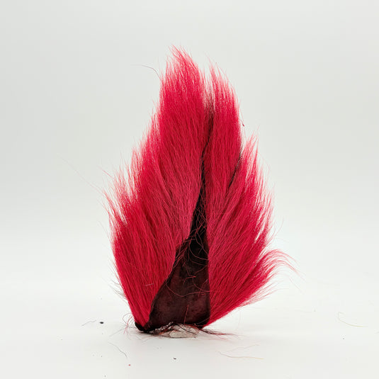 Red bucktail-style fly tail with dark mottled base