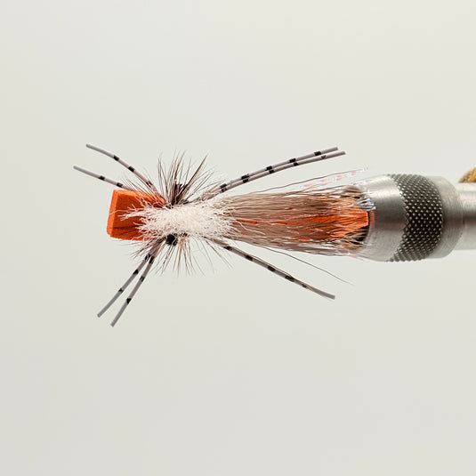 Orange foam hopper fly on metal cone, black head, sparse legs and orange foam body