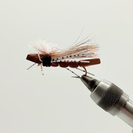 Brown foam hopper fly with silver hook, brown body, and orange-white hackle