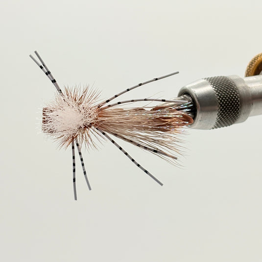 Brown foam hopper fly with black-and-white barred legs and orange-brown hackle