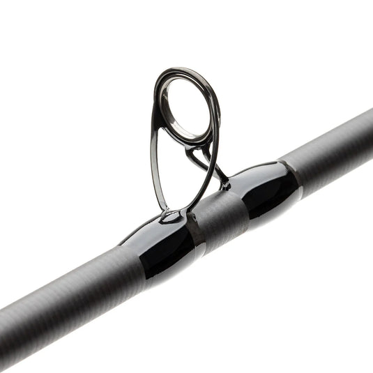 Fly fishing rod close-up of metal line guide on a dark shaft