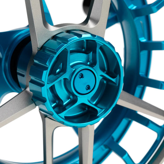 Fishing reel close-up of blue spool cover and silver support arms