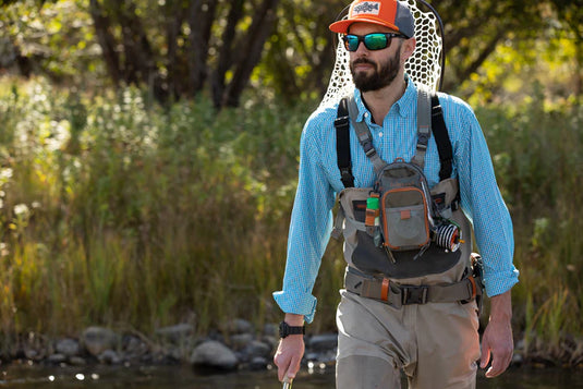 Chest pack worn on chest with adjustable straps and orange-accented front pocket