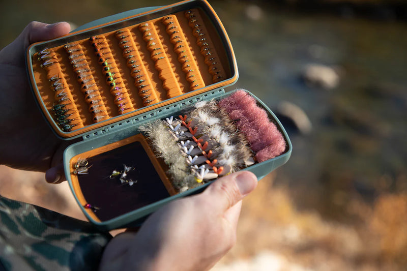 Load image into Gallery viewer, Fly fishing lure storage case held open, showing orange foam and feather lure flies
