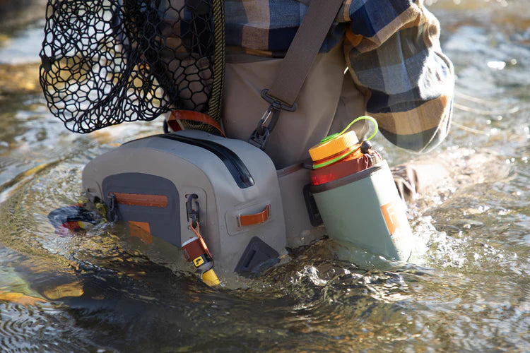 Load image into Gallery viewer, Submersible lumbar pack on water with bottle holder and orange-accented front pouch.
