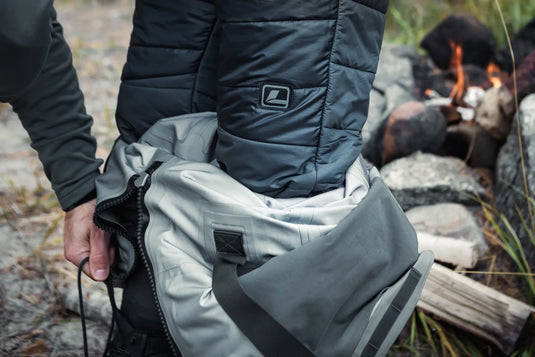 Insulated pants detail: light gray fabric, black panel, side zipper and pocket patch