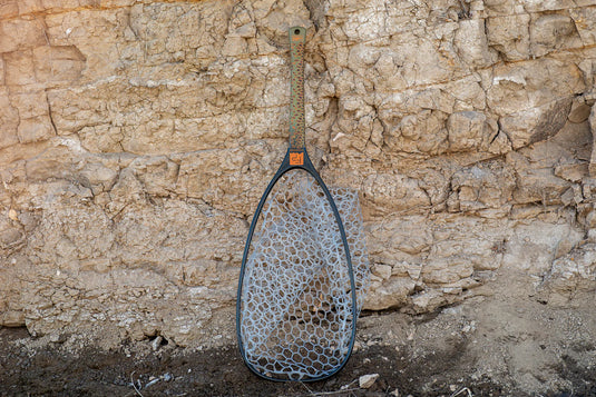 Fish landing net with dark mesh and long handle, oval scoop