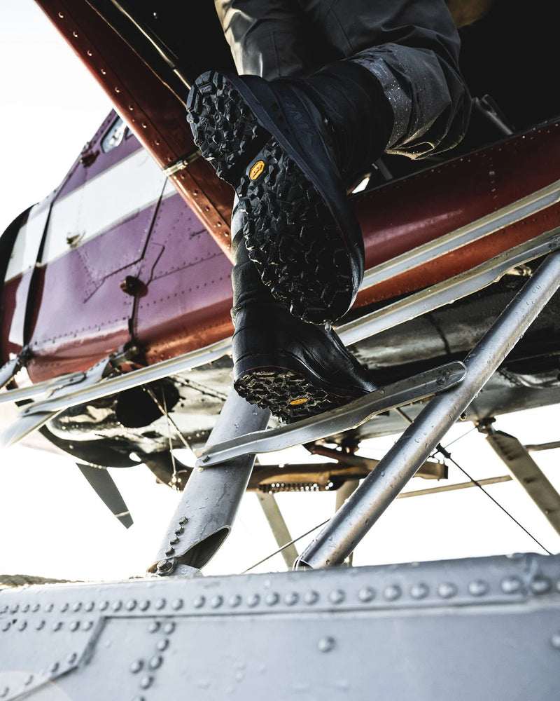 Load image into Gallery viewer, Men’s guide boot stepping on metal rails, showing black rubber sole tread

