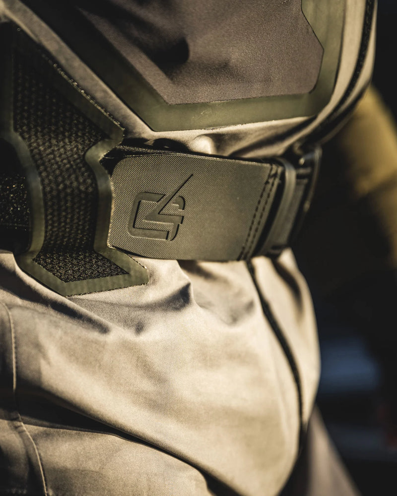 Load image into Gallery viewer, Close-up of gray wader fabric with embossed icon near the chest
