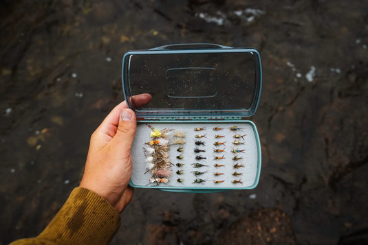 Fishpond fly box held open, clear lid and foam tray with neatly arranged flies