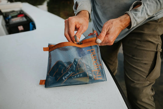 Fishpond sandbar travel pouch with orange zipper, partially open with lining