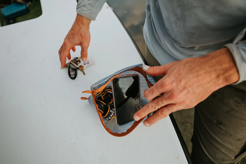 Load image into Gallery viewer, Fishpond mesh travel pouch with orange trim, open zipper and visible interior
