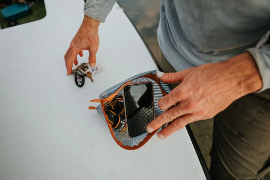 Fishpond mesh travel pouch with orange trim, open zipper and visible interior