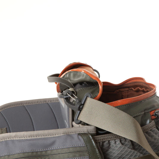 Lumbar pack detail: orange-lined zipper, gray strap, and side attachment tabs