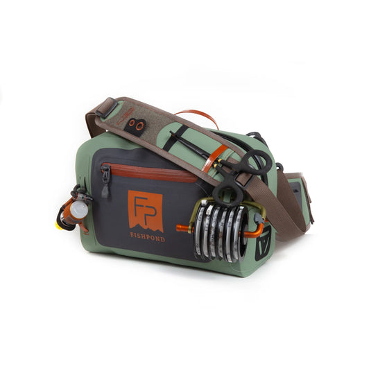 Olive green lumbar submersible pack with side-mounted gear holder and brown shoulder strap
