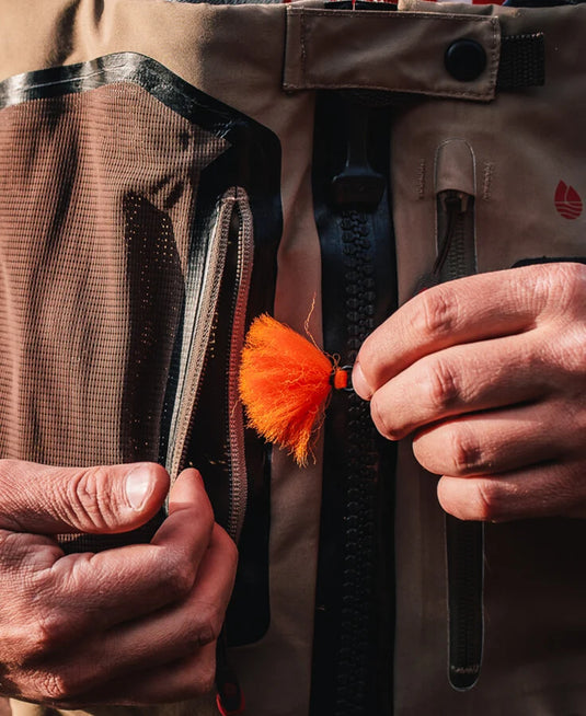 Orange yarn indicator attached to a jacket zipper pull.