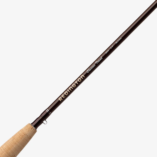 Fishing rod close-up with Redington Classic Trout text on dark blank and cork grip