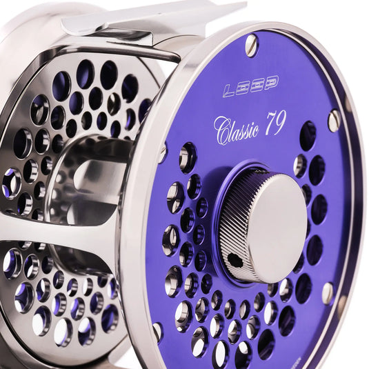Purple fishing reel with perforated spool and textured drag knob