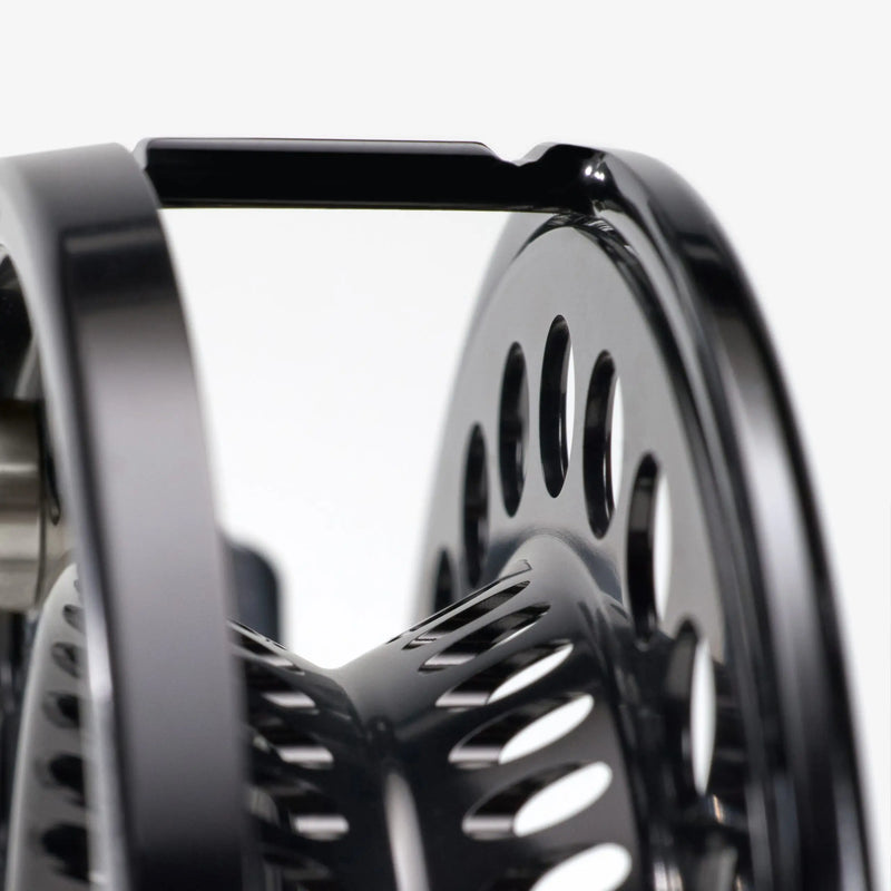 Load image into Gallery viewer, Fishing reel side view with glossy black rim and silver center spindle
