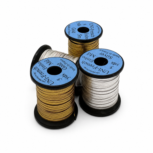 Embossed metallic thread spools in gold and silver with blue labels