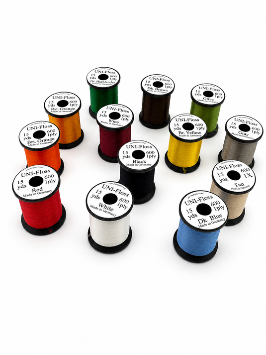 Assorted embroidery floss spools in dark red, black, white, tan, yellow, green, and blue.