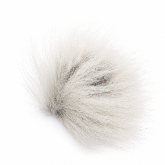 White arctic fox fur pom-pom, fluffy plush texture