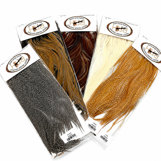 Root River Saddle feather packs in brown, ginger, cream, and dark gray