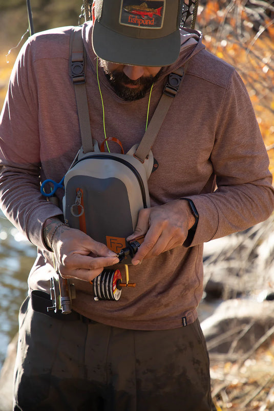 Chest-mounted submersible pack with gray front pouch, orange zipper tabs, shoulder straps