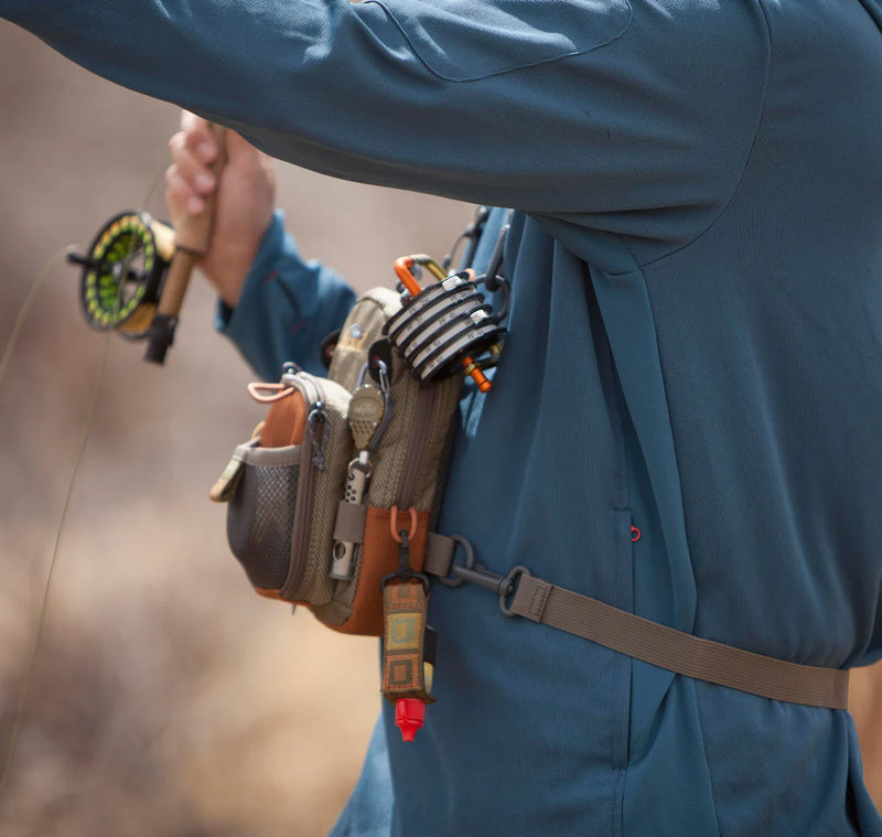 Load image into Gallery viewer, Fishpond San Juan vertical chest pack with front organizer and side clips on blue jacket
